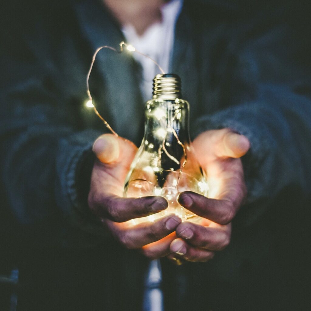 Imagen de stock mostrando unas manos con un bombillo de luz para un artículo acerca de Startups en Colombia