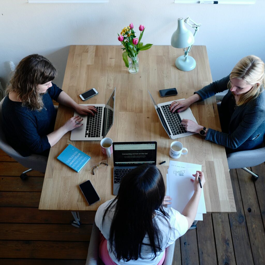 tres mujeres trabajando en sus respectivos laptops, representando a una reunión de creadores de empresa en Colombia. 